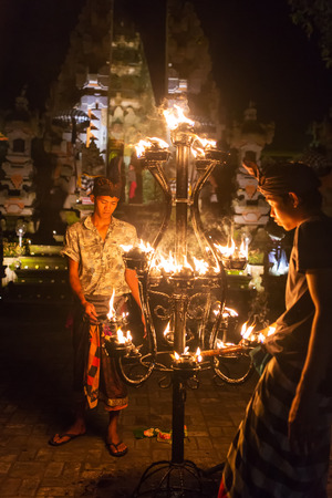 Ubud, Indonesia - August 8, 2016: Unidentified balinese men light candles before a traditional Kecak Fire Dance ceremony in Hindu temple.のeditorial素材