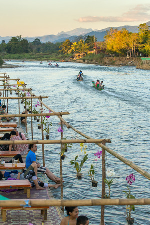 Vang Vieng, Laos - January 19, 2017: Tourists enjoy sunset in river cafe in Vang Vieng village, Laosのeditorial素材
