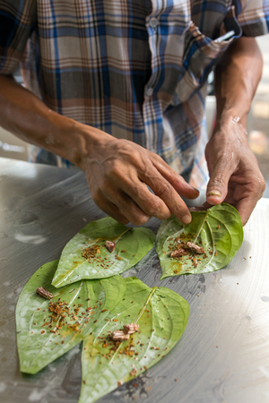 Man making betel nut on the street stall in Myanmar (Burma).の写真素材