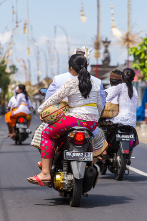 Bali, Indonesia - September 7, 2016: Balinese family on riding motorbike on streets of Ubud during Galungan celebration.のeditorial素材