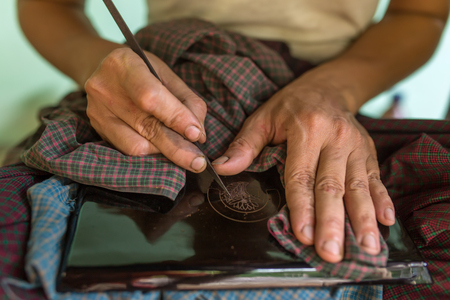 Burmese woman working in a factory of lacquer in Bagan, Myanmar. Lacquerware includes boxes, tableware, buttons, plates etcの写真素材
