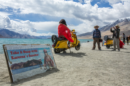 Pangong Tso, India - June 11 2017: Unidentified Indian tourists making photo on famous yellow scooter that was used in filming famous Bollywood movie 3 idiots.のeditorial素材