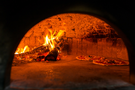Original neapolitan pizza margherita in a traditional wood oven in Naples restaurant, Italyの写真素材