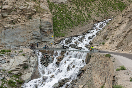 Ladakh, India - July 18, 2017: Biker crossing the river flowing on the road from melting glacier in Himalaya mountains, Ladakh region, Indiaのeditorial素材