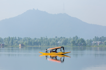 Srinagar, india - June 15, 2017: Man riding a shikara boat on the Dal lake in Srinagar, Kashmir, India.のeditorial素材