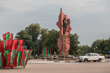 Mozyr, Belarus - September 23, 2017: Lenin statue on Lenin square with flags in  national colors and  soviet retro car in Mozyr, Southern Belarusのeditorial素材