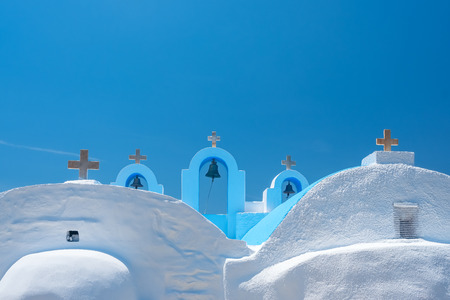 Cycladic greek orthodox church on Paros island, Greece. White crosses against blue sea and skyの写真素材