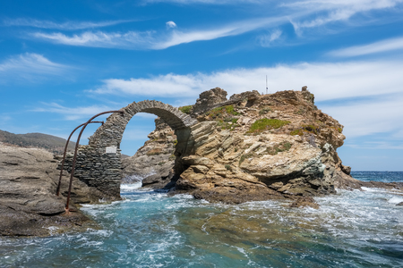 Old arched stone bridge in the beautiful town of Chora on Andros island, Cyclades, Greeceの写真素材