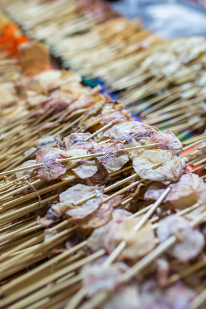 Close-up of sticks of dry squid on the street market in Thailand. Traditional thai street foodの写真素材