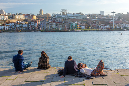 Porto, Portugal - January 19, 2018: Unidentified people rest on the Douro riverside at sunny day in Porto, Portugalのeditorial素材