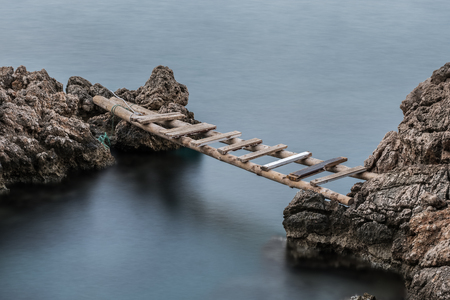 Long exposure scene with old wooden stairs used as a bridgeの写真素材