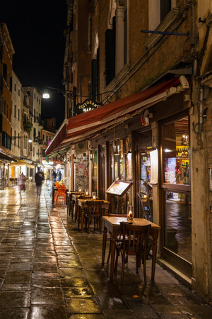 Venice, Italy - March 19, 2018: Outdoor cafe at narrow street in Venezia at nightのeditorial素材