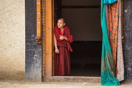 Tibetan buddhist monk watching mask festival from Lamayuru monastery door in Ladakh, Indiaのeditorial素材