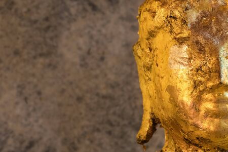 Buddha statue covered with golden papers close up.の写真素材