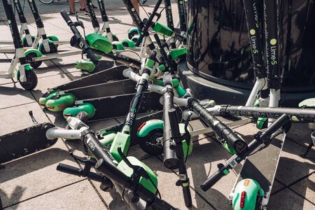 Many electric scooters, escooter or e-scooter of the ride sharing company LIME left on sidewalk in Warsaw, Polandのeditorial素材