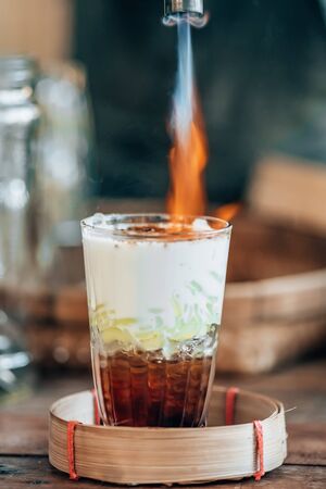 Caramelizing sugar with fire on top of traditional thai dessert called Cendolの写真素材