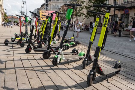 Many electric scooters, escooter or e-scooter of the ride sharing company HIve left on sidewalk in Warsaw, Polandのeditorial素材