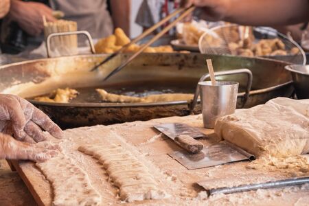 Chef cooking deep fried dough sticks - traditional thai street food dessertの写真素材
