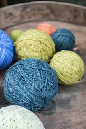 Balls of yarn for knitting in a wooden tray. Colorful knitting thread close-up