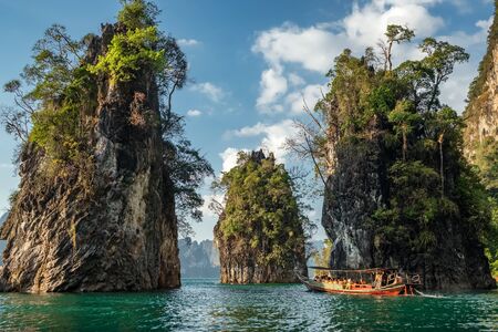 Wooden traditional thai longtail boat on Cheow Lan lake in Khao Sok National Park, Thailandの写真素材