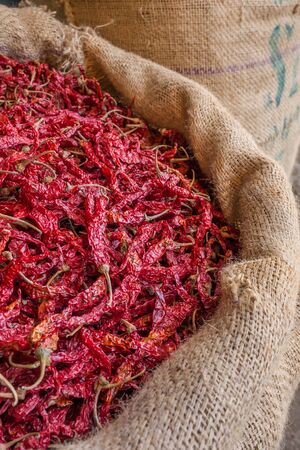 Dried red chili peppers in sacks for sale at the marketの写真素材