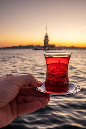 Traditional turkish tea in a glass with Maiden Tower at background in Istanbul, Turkeyの写真素材