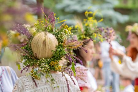 Unidentified women in traditional dresses with summer solstice wreaths made from field flowers, grasses and cereals.の写真素材