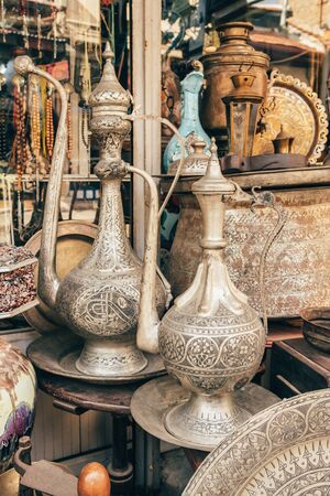 Old metal olive oil cruets displayed in the antique shop