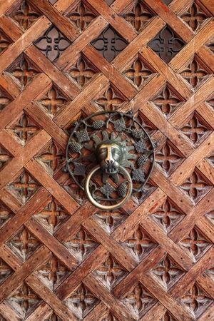 Old medieval wooden door with metal door knocker in the shape of lion headの写真素材