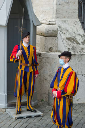Papal Swiss Guards in uniform with protective medical mask at st. Peters square in Vatican during Covid 19 pandemicのeditorial素材