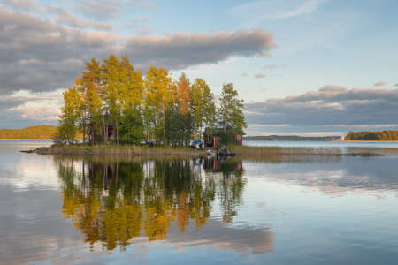 Small island on the lake with country house in Finland.の写真素材