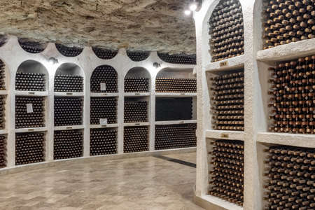 Wine bottles stacked up in old wine cellar close-up
