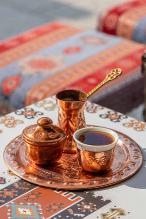 Traditional black bosnian coffee in beautiful copper cezve on the table in old town of Sarajevoの写真素材