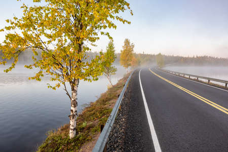 Finnish landscape with narrow car road through the lake.の写真素材