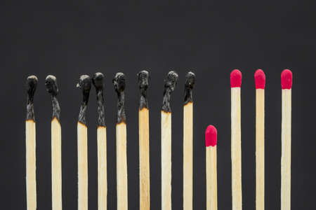 Healthy matches keep social distance with burnt ones. Stop epidemic. Domino effectの写真素材