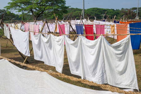 Laundry drying on a rope in the yard in the sunlightの写真素材