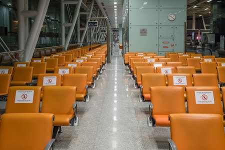 Signs on the chairs reminding about importance of social distancing during pandemic of Covid-19