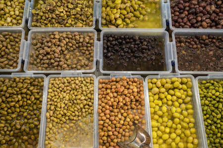 Different types of olives at street marketの写真素材
