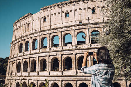 Young woman take a picture of Colosseum by smartphone in Romeの写真素材