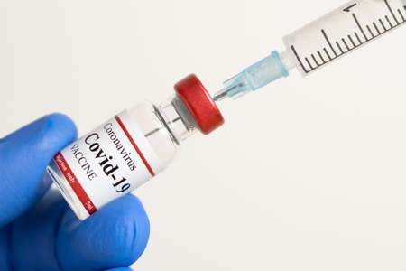 Doctor holding Coronavirus vaccine and syringe using for prevent COVID-19 infection.の写真素材