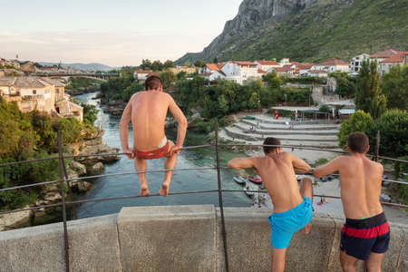 Man jumping from a very high ancient bridge in Mostar, Bosnia and Herzegovinaのeditorial素材