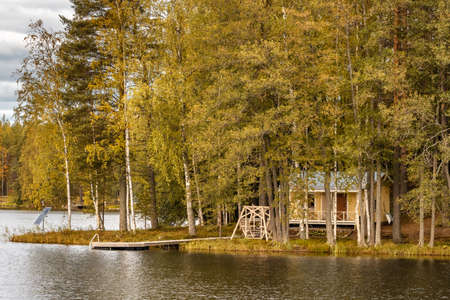 Small island on the lake with a country house in Finland.の写真素材