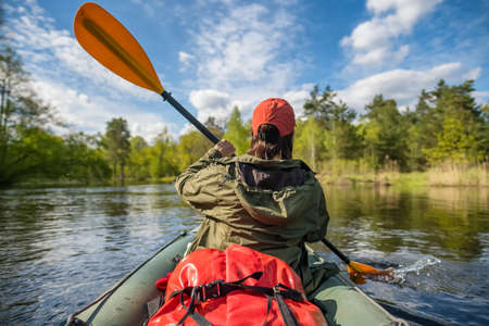 Woman rowing a kayak at a beautiful sunny spring dayの写真素材