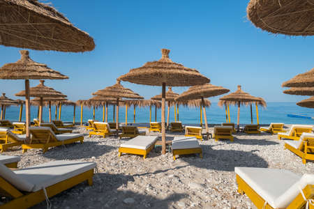 Beautiful empty beach with umbrellas and sunbedsの写真素材
