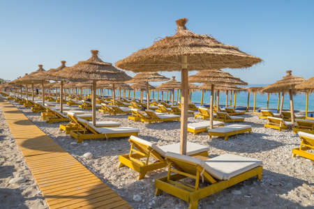 Beautiful empty beach with umbrellas and sunbedsの写真素材