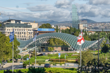 Tbilisi cityscape with Modern Peace Bridge and national Georgian flag, Georgia.のeditorial素材