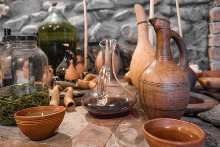 Young wine in clay bowl next to vintage georgian terracotta jug in authentic Georgian wine cellar.の写真素材