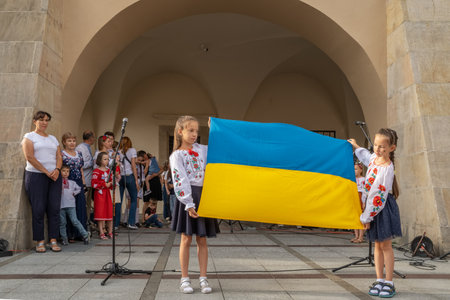 Ukrainian refugee girls holding national flag of Ukraineのeditorial素材