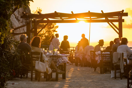 Unidentified people enjoy sunset in Sunset Michali Taverna on the Zakynthos island, Greece