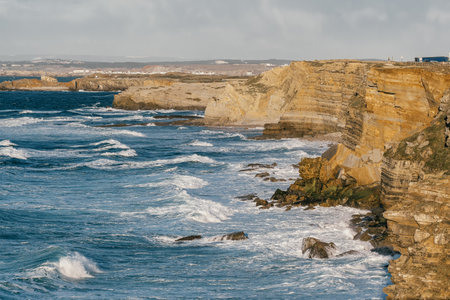 Ocean wave breaking on a rocky shore with rough sea water in Portugal